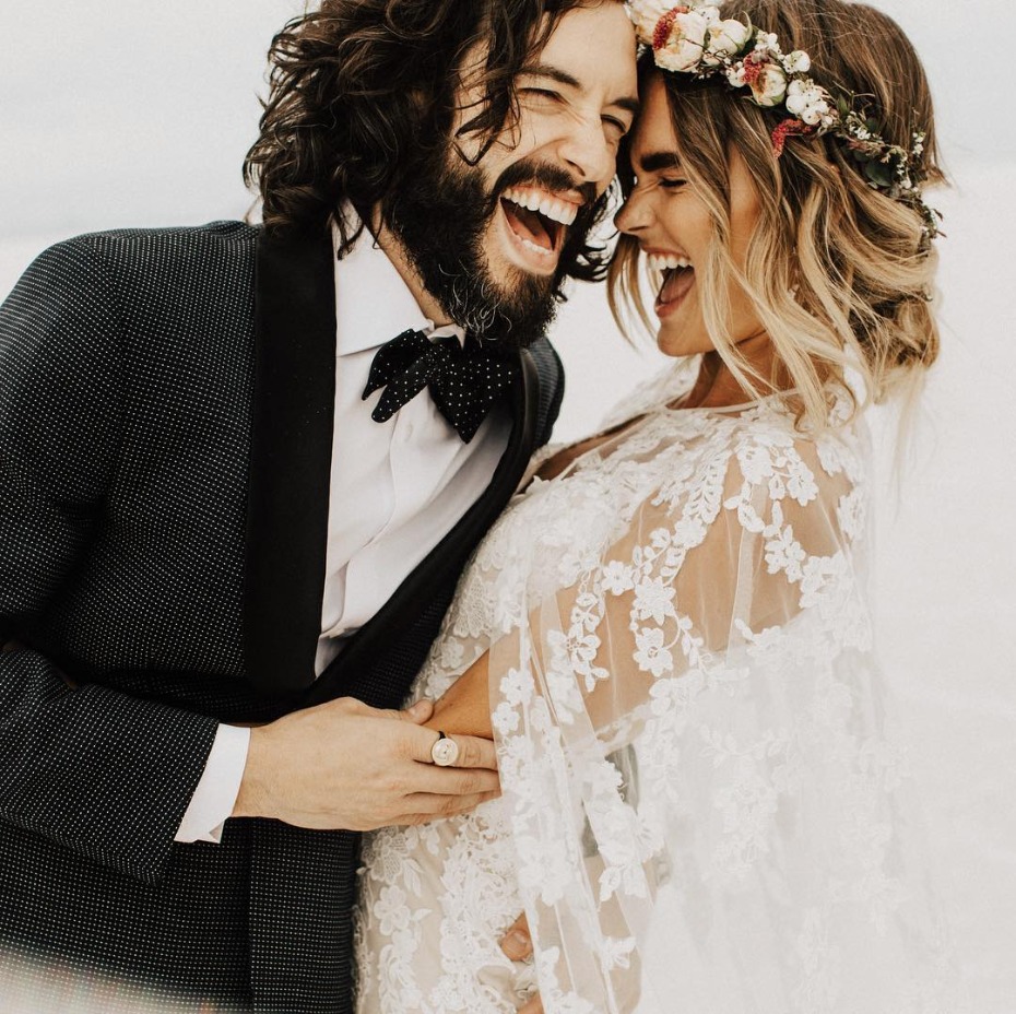 Newlyweds laughing at their wedding, joyful couple with flower crown