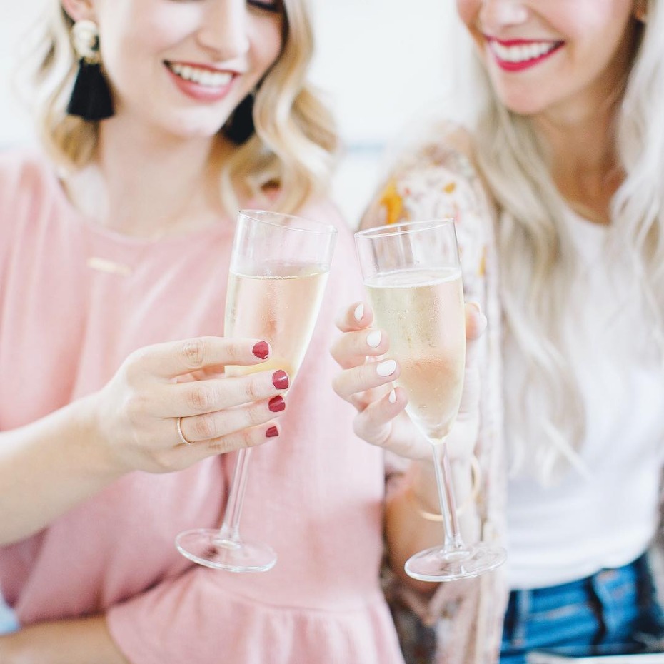 Girlfriends toasting with bright smiles and champagne photo by Kristen Booth Photography