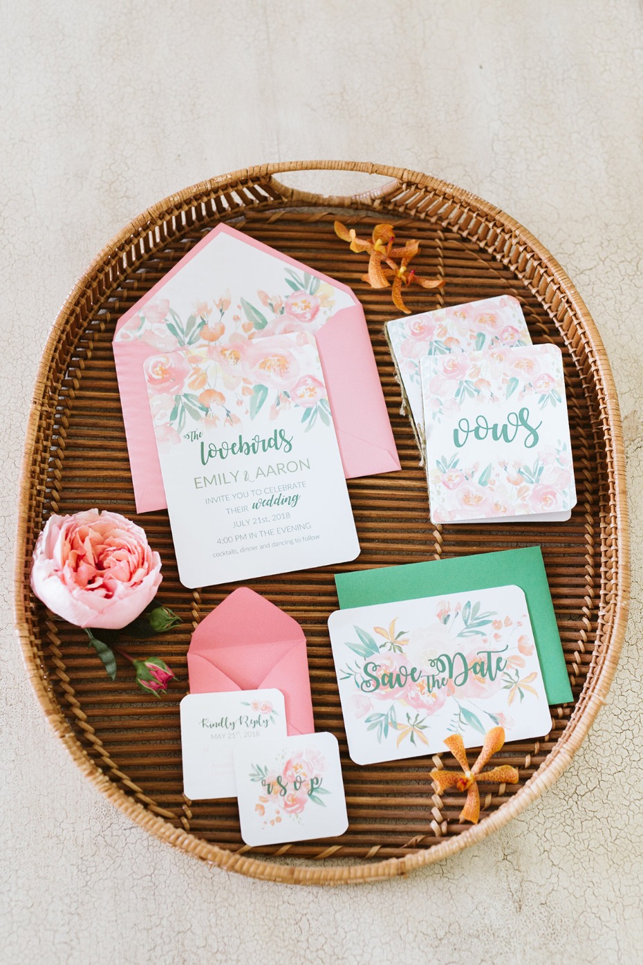 Wedding stationery with floral design on a woven tray