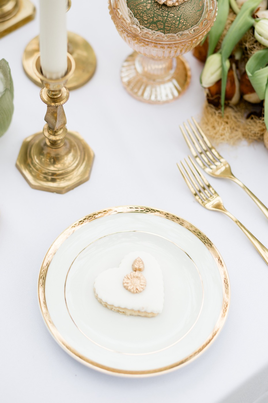 Elegant table setting with heart-shaped cookie and golden accents