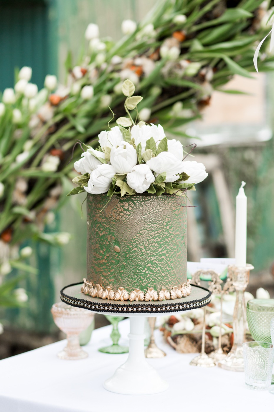 A beautiful green cake with white floral decorations for celebration