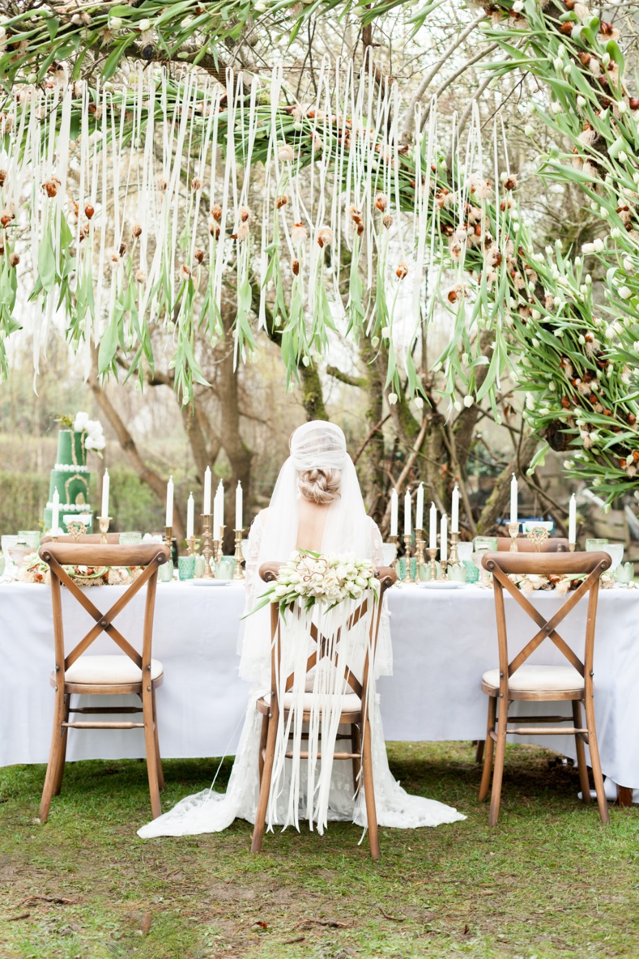 A cat dressed in a wedding dress, at a beautiful outdoor table
