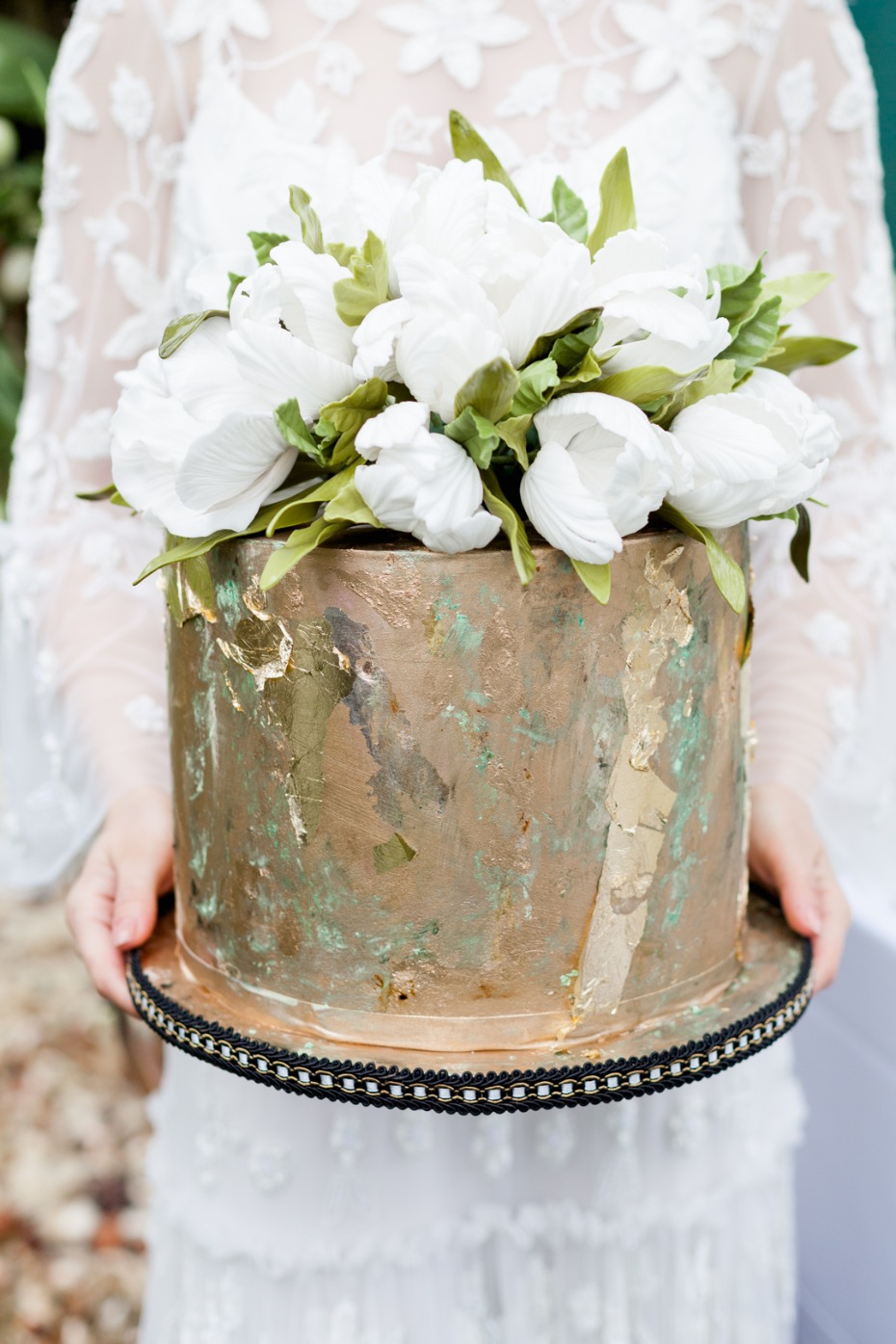Elegant wedding cake with gold leaf and flower decorations