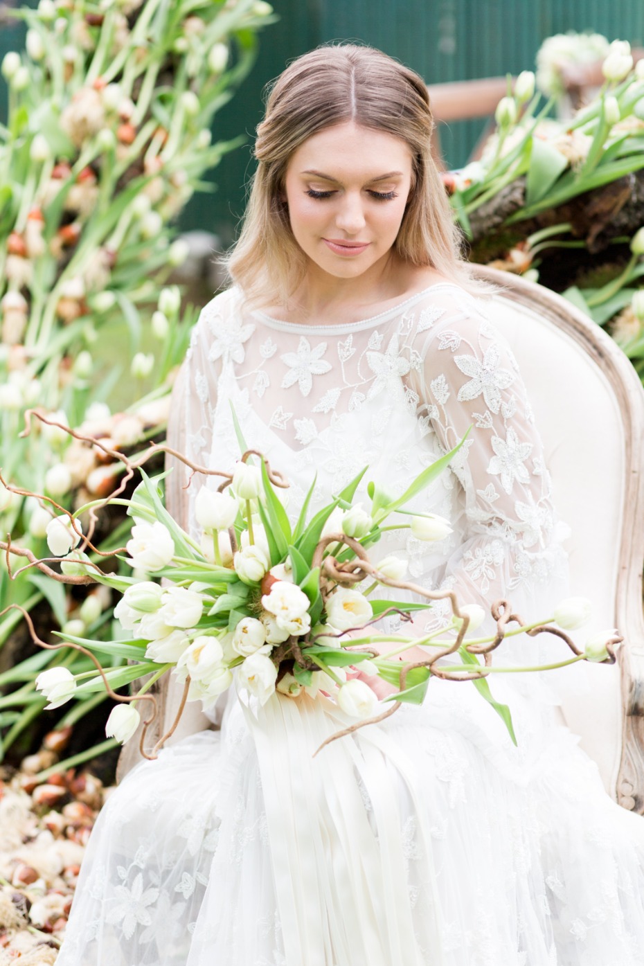 Elegant bride in lace dress with white tulips bouquet