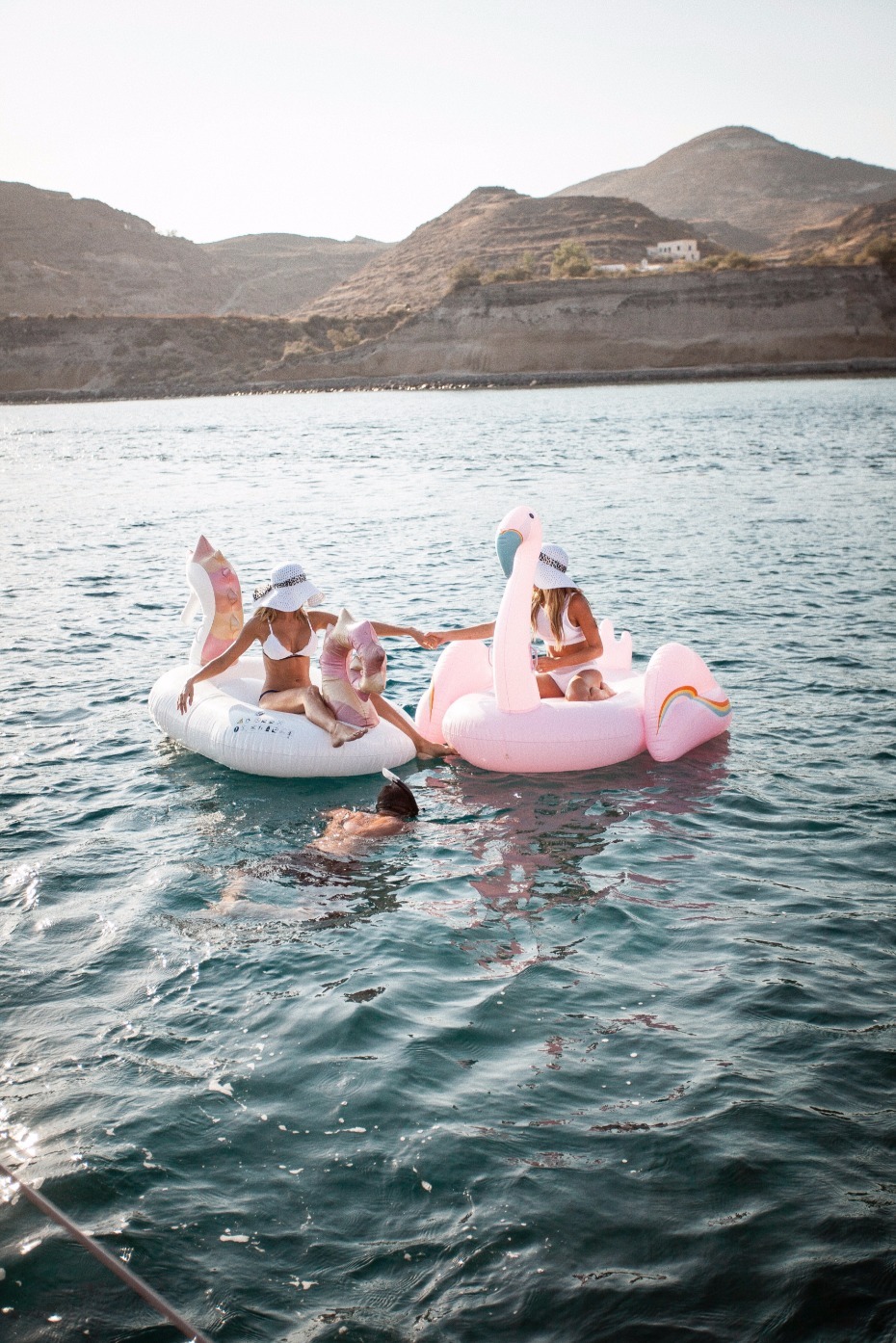 Friends enjoying a summer day on inflatable flamingo floats
