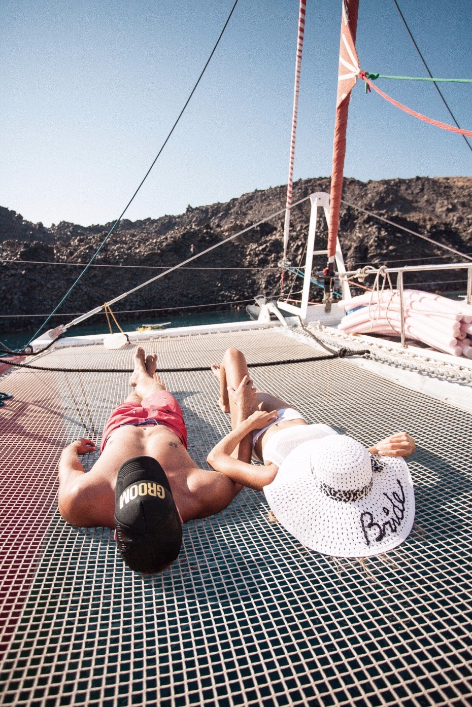 Newlyweds relaxing on a yacht, enjoying a sunny honeymoon
