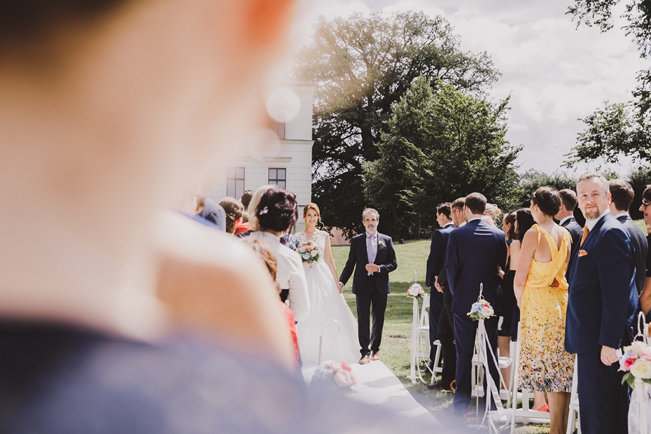 Bride walking down the aisle with her father during a wedding ceremony