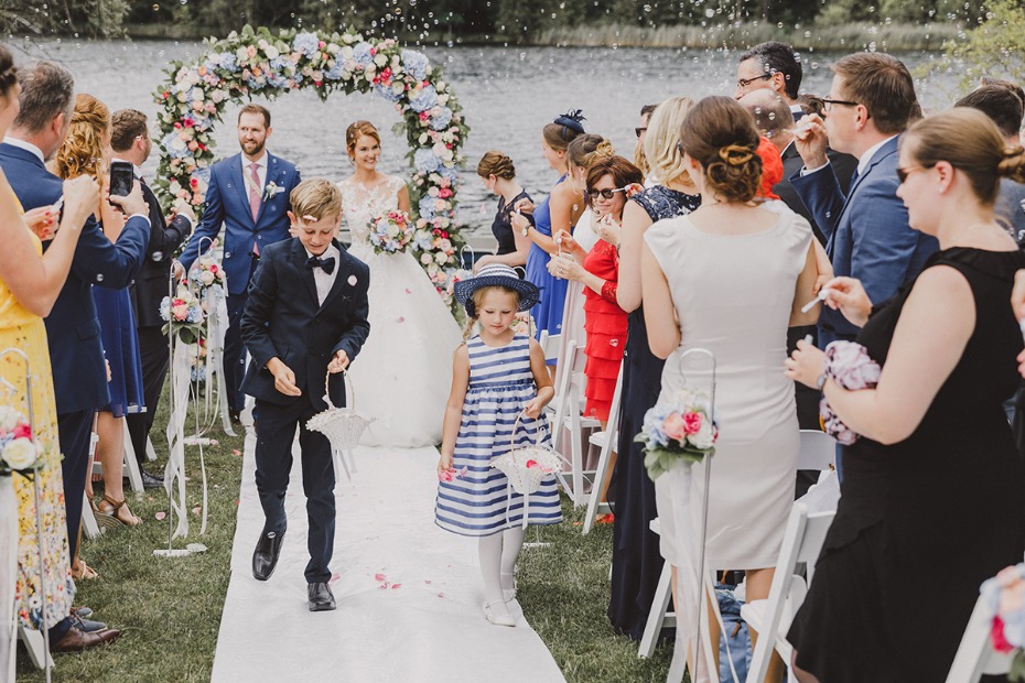Wedding ceremony with flower arch and joyful guests present