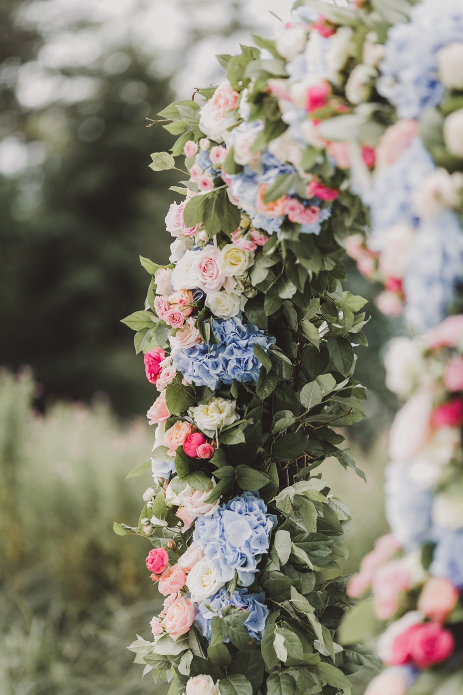 Wedding arch adorned with colorful hydrangeas and roses