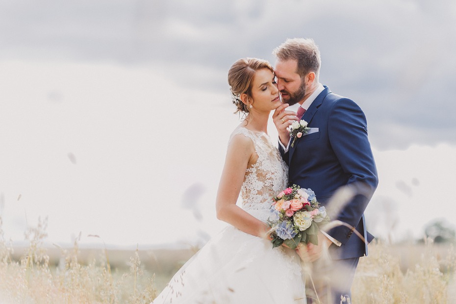 Romantic wedding photo of a couple embracing outdoors