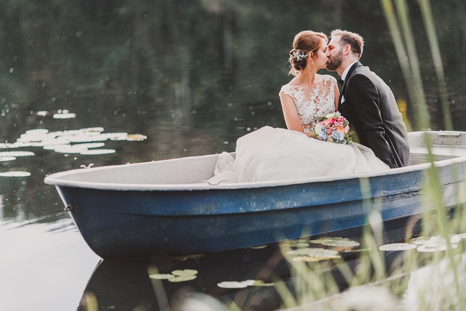 Bride and groom kissing on a boat after their wedding ceremony