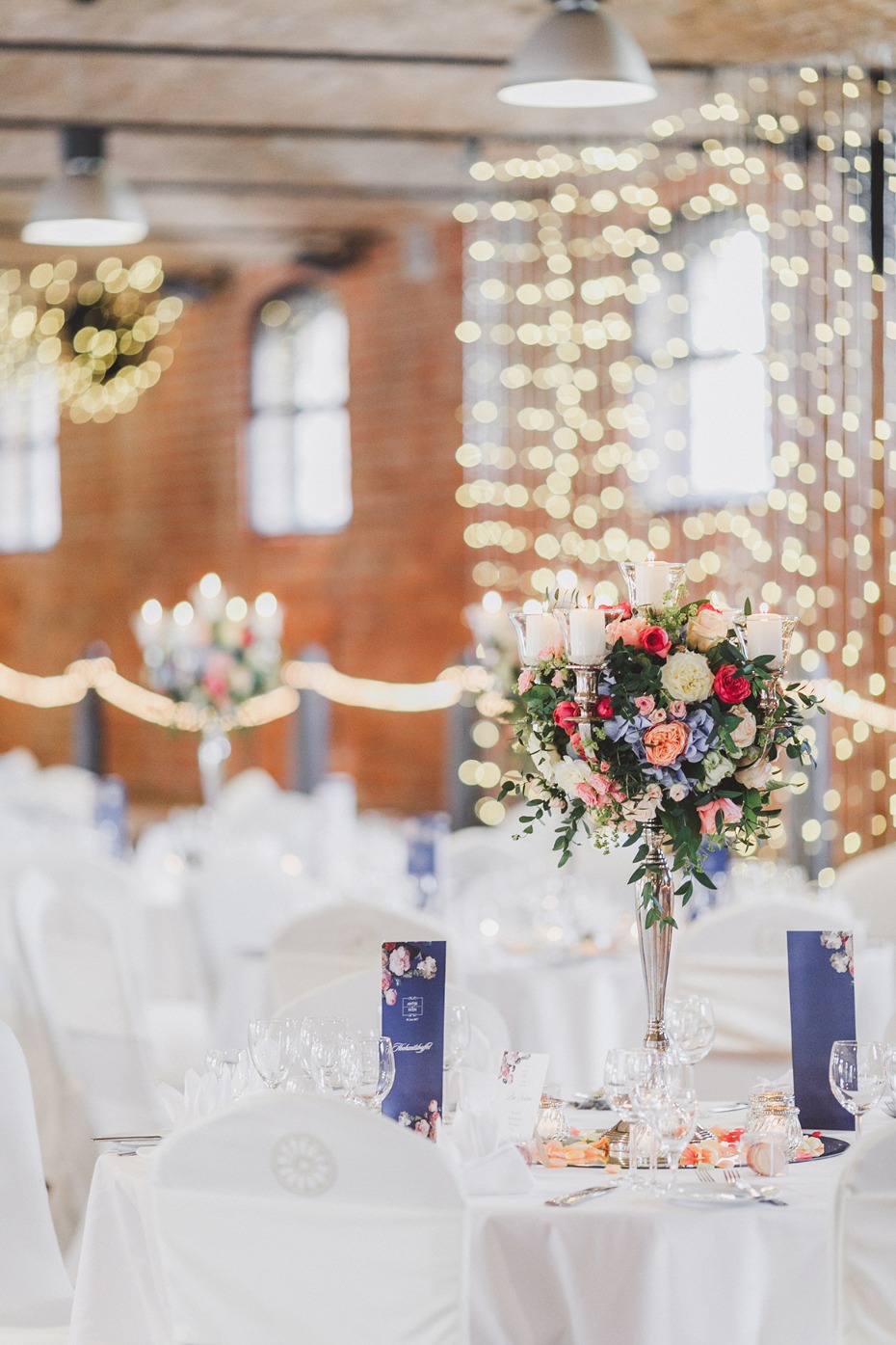 Elegant wedding reception table with floral centerpiece and lights