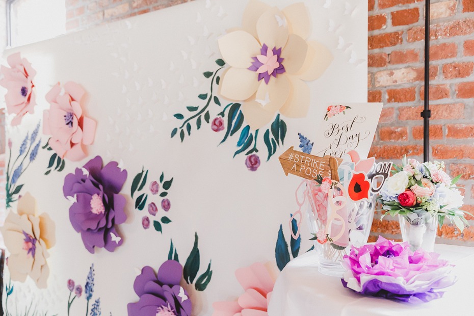 Wedding photo booth backdrop with paper flowers and props