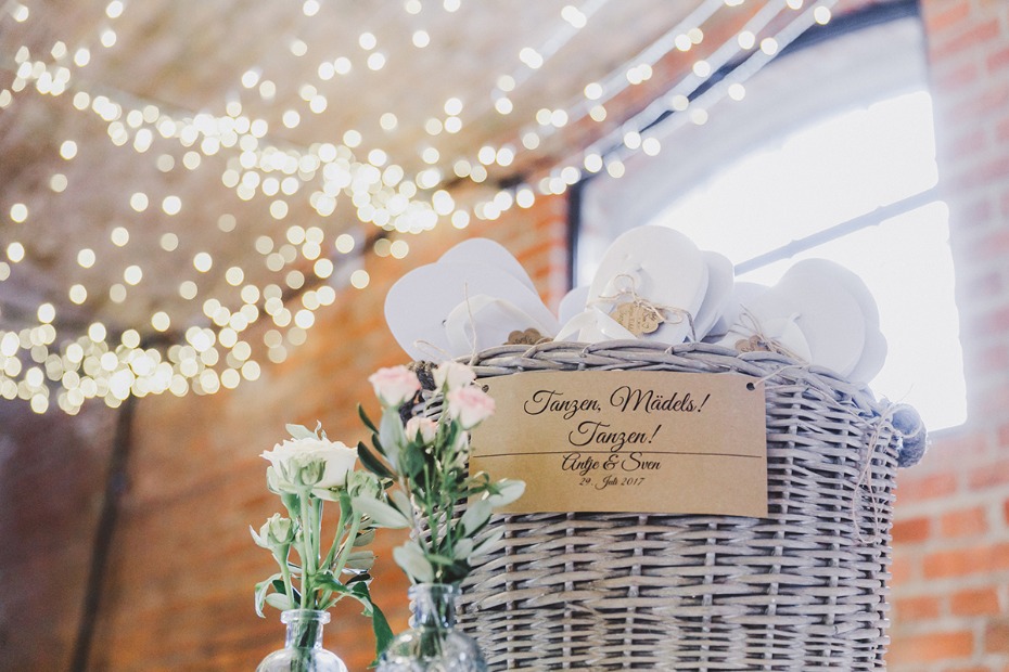 Wedding basket with dancing shoes, flowers, and festive lights