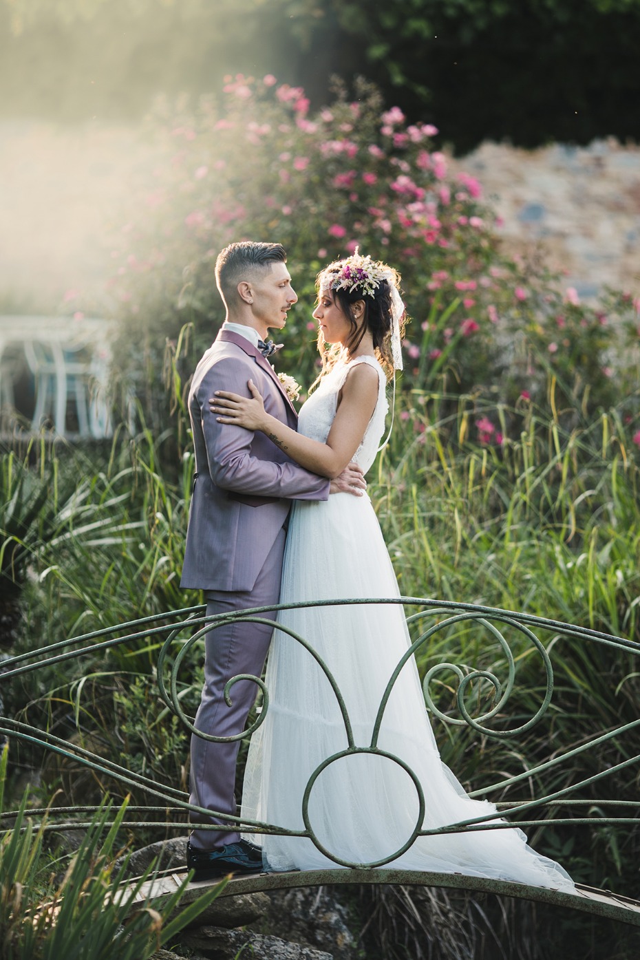Romantic wedding couple embracing on a bridge