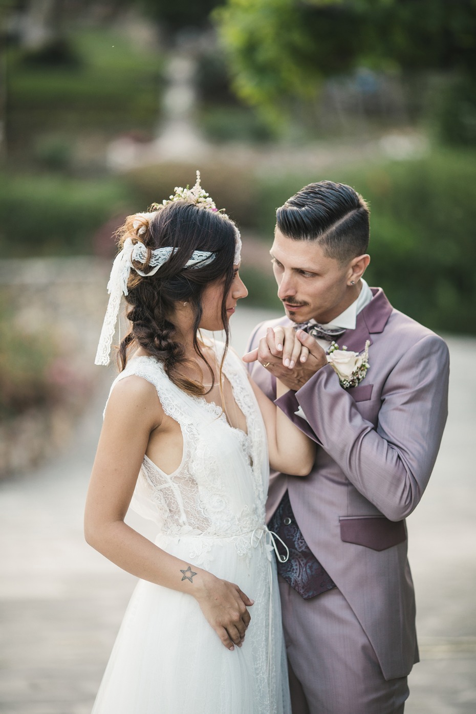 Romantic wedding photo of groom kissing brides hand