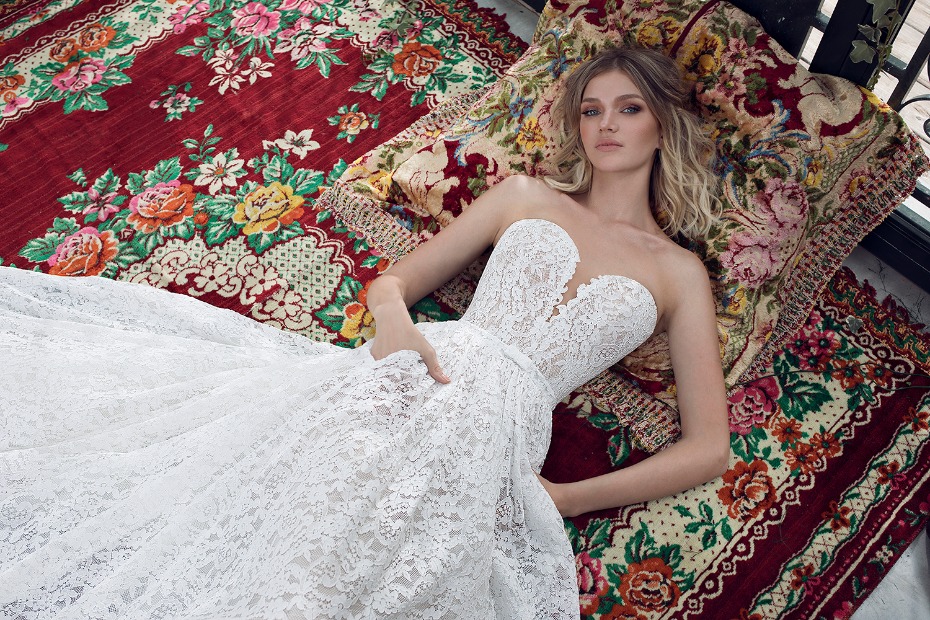 Elegant bride in a lace dress relaxing on a floral patterned rug