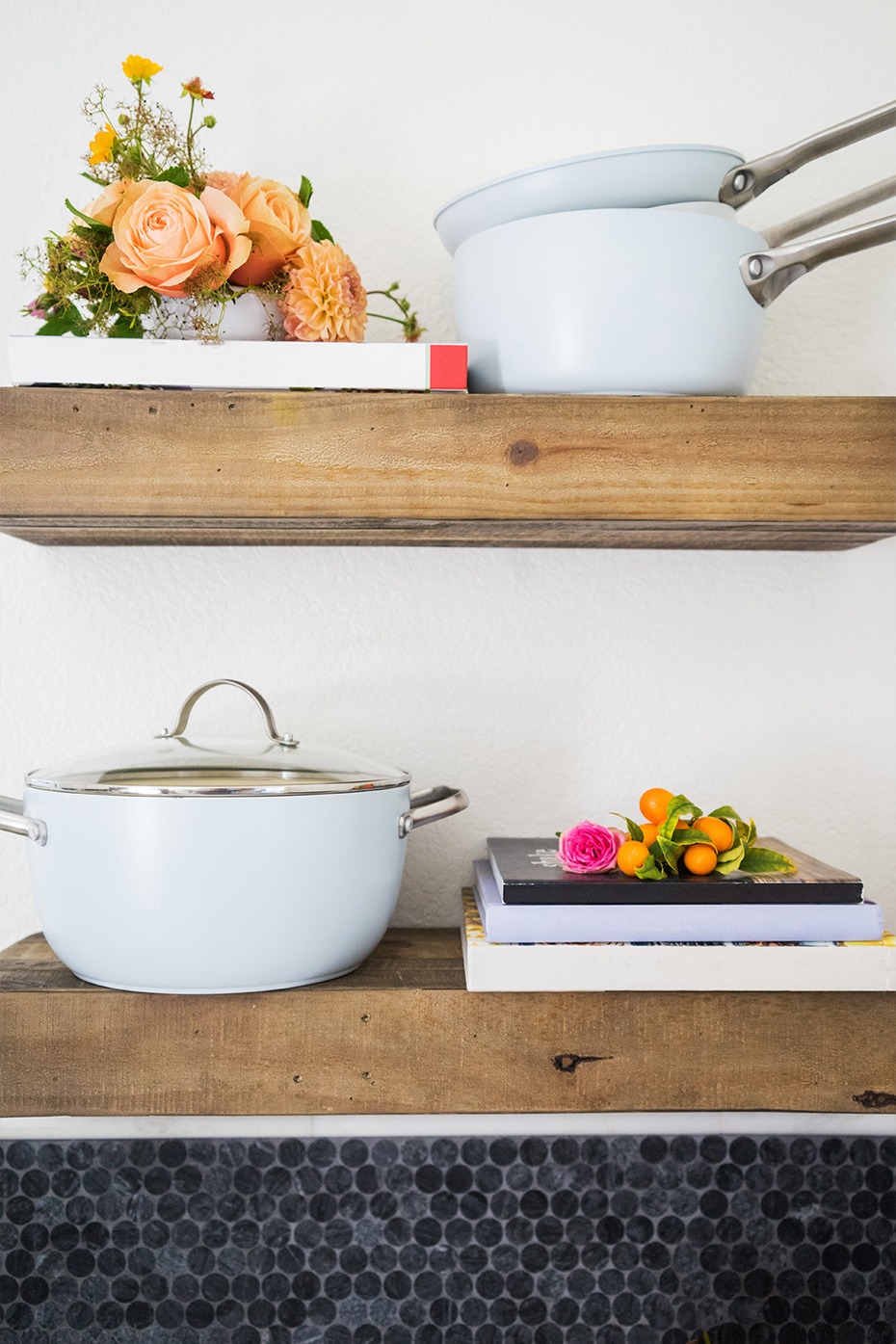 Wooden shelves with flowers, pots and books, kitchen interior