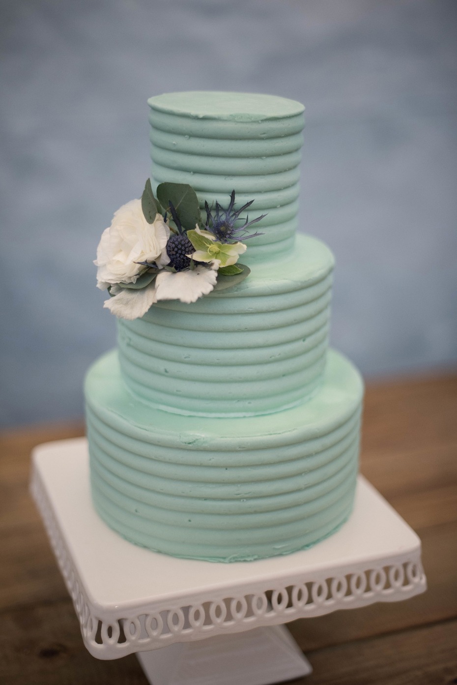 teal wedding cake topped with florals