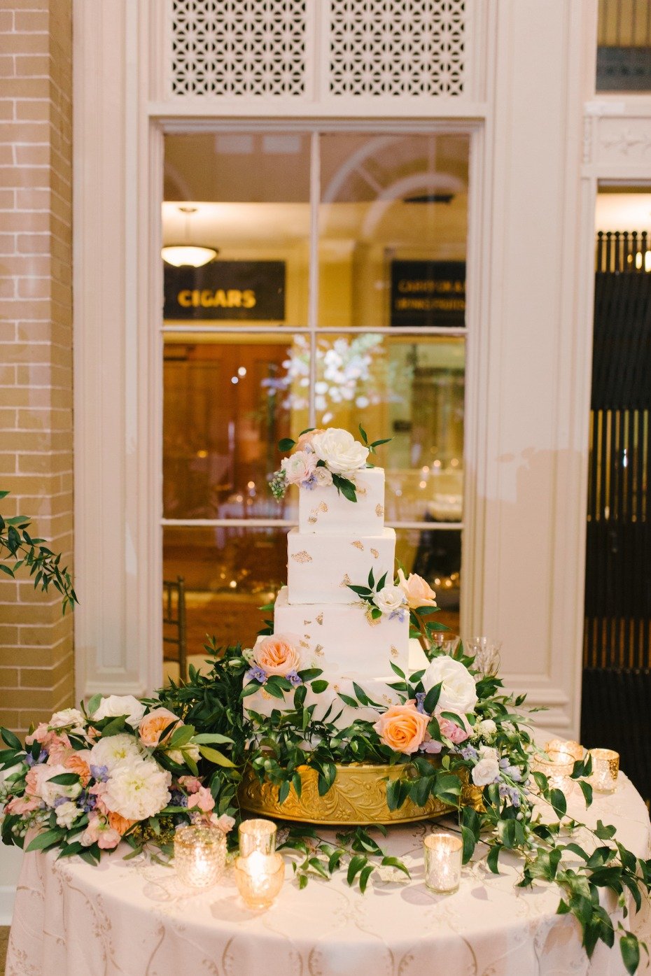 wedding cake table with cascading floral decor