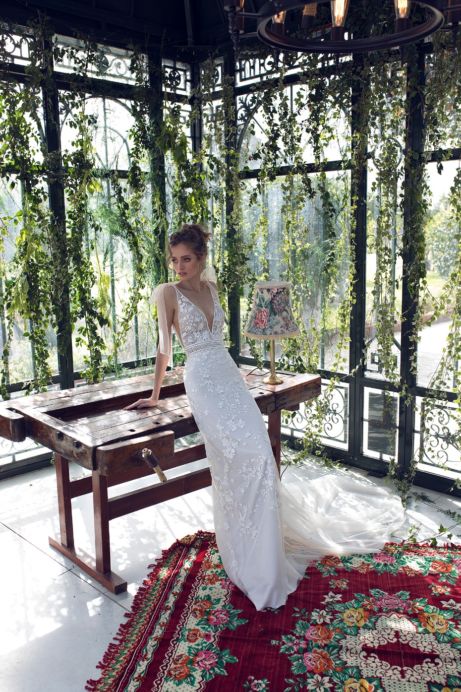 Elegant bride in a floral wedding dress, posing indoors