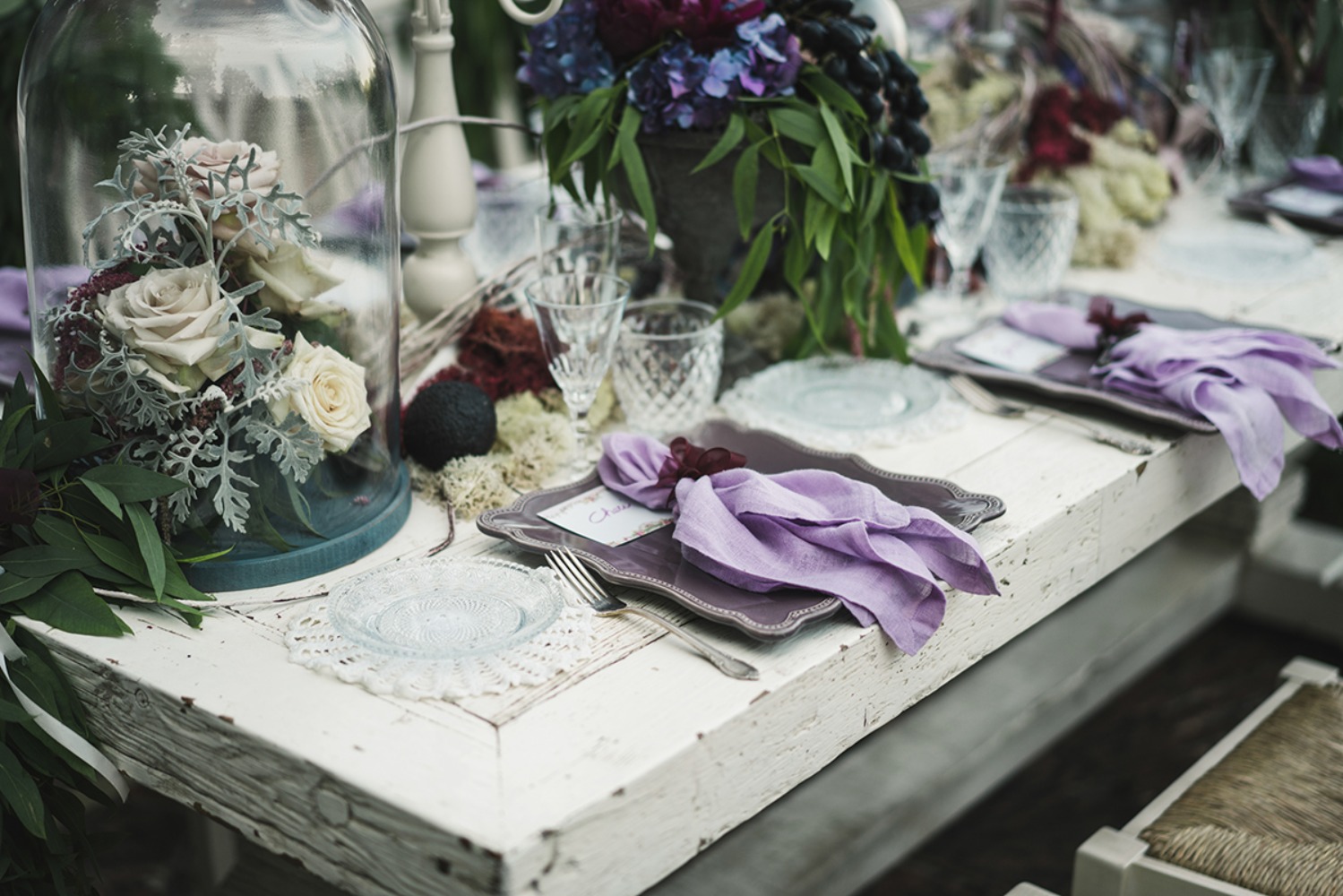Elegant rustic wedding table decor with purple napkins