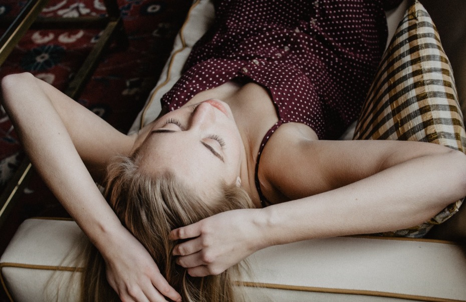 Woman relaxing with closed eyes lying on a sofa looking peaceful