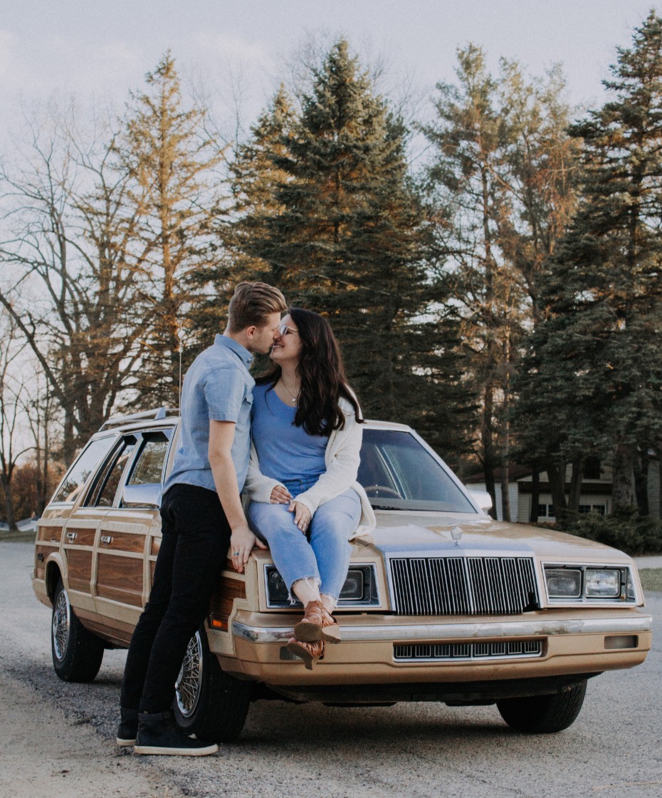 Couple kissing on a station wagon