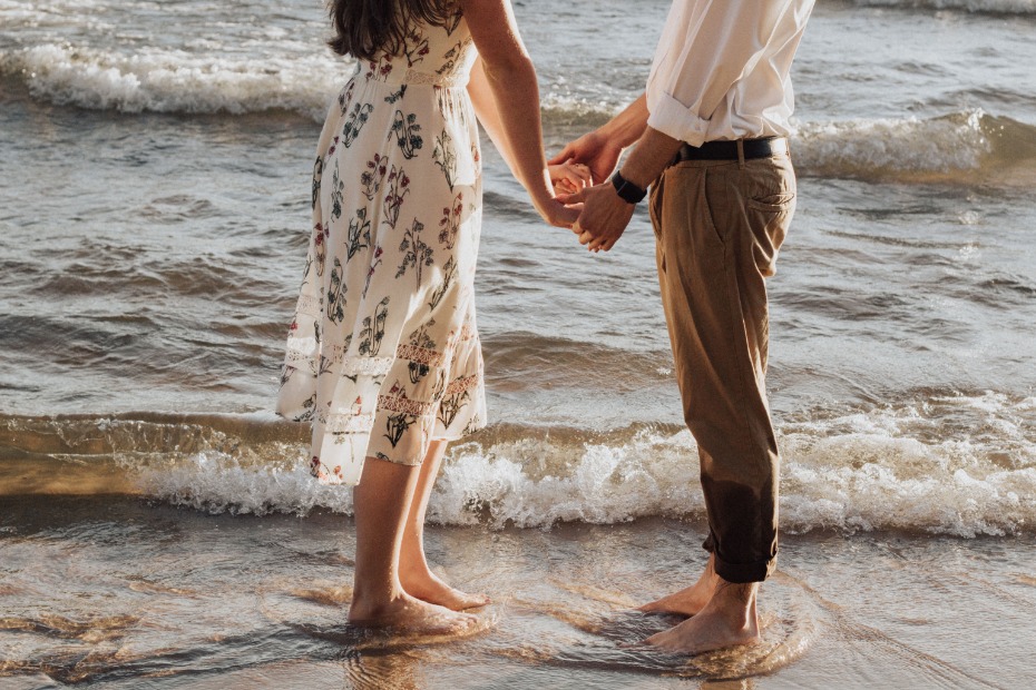 Couple holding hands at the beach, romantic summer vibes