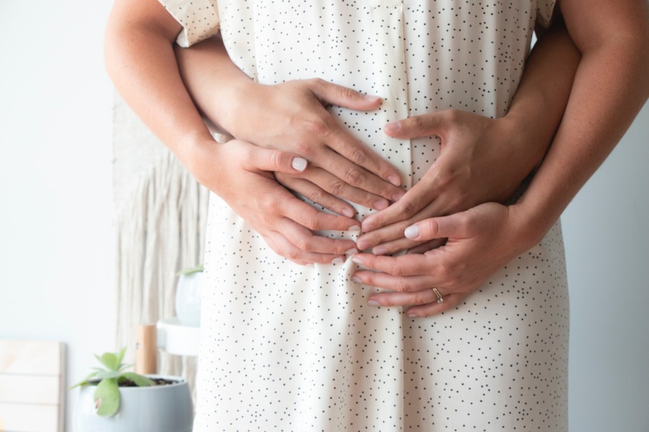 Pregnant couple with hands on belly