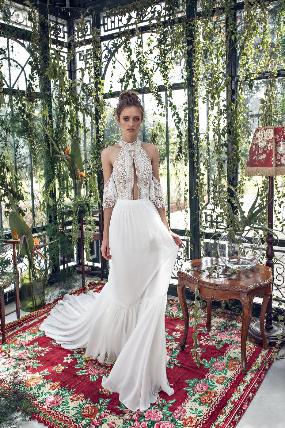 Elegant bride in a flowing white dress in a greenhouse setting