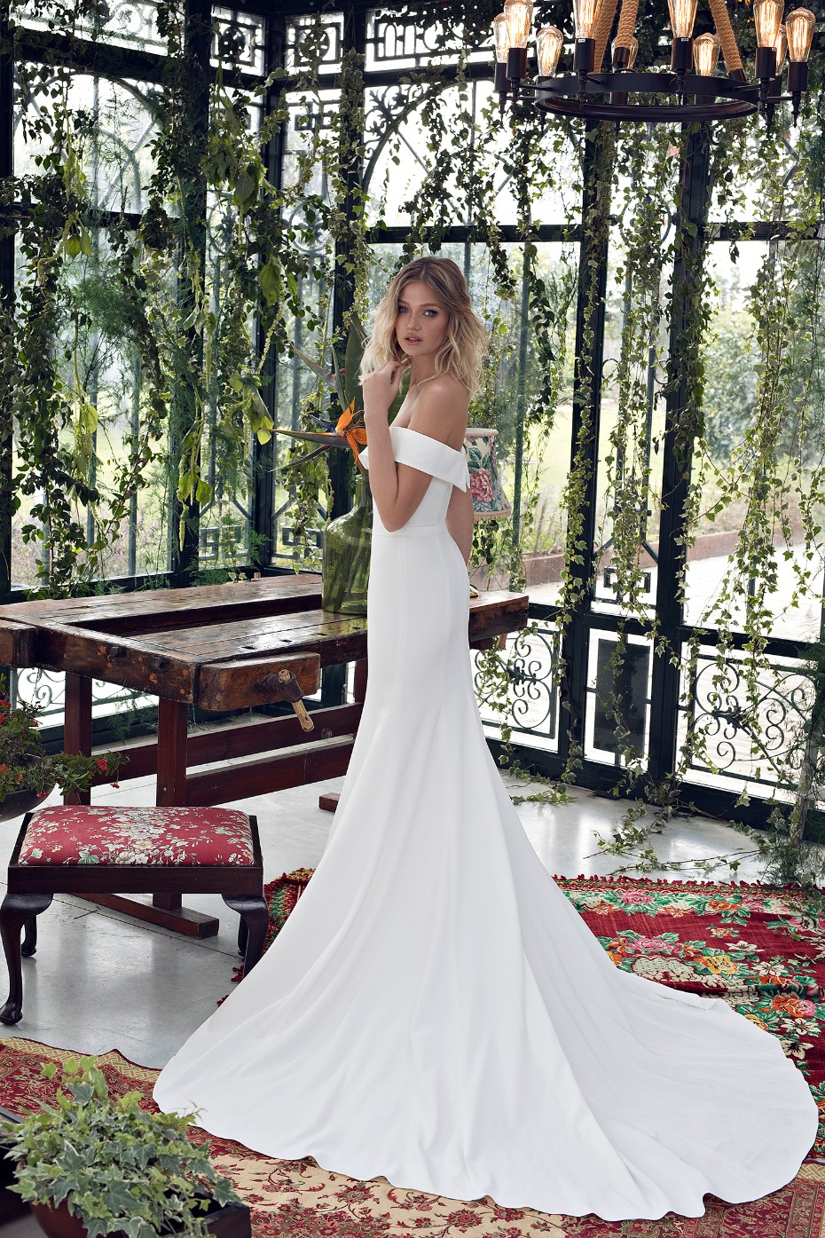 Elegant bride in a white gown smiles amidst a lush garden setting