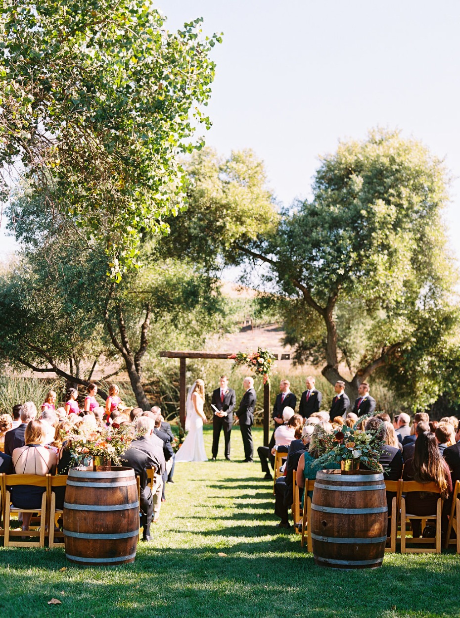 Outdoor wedding ceremony with guests seated under trees