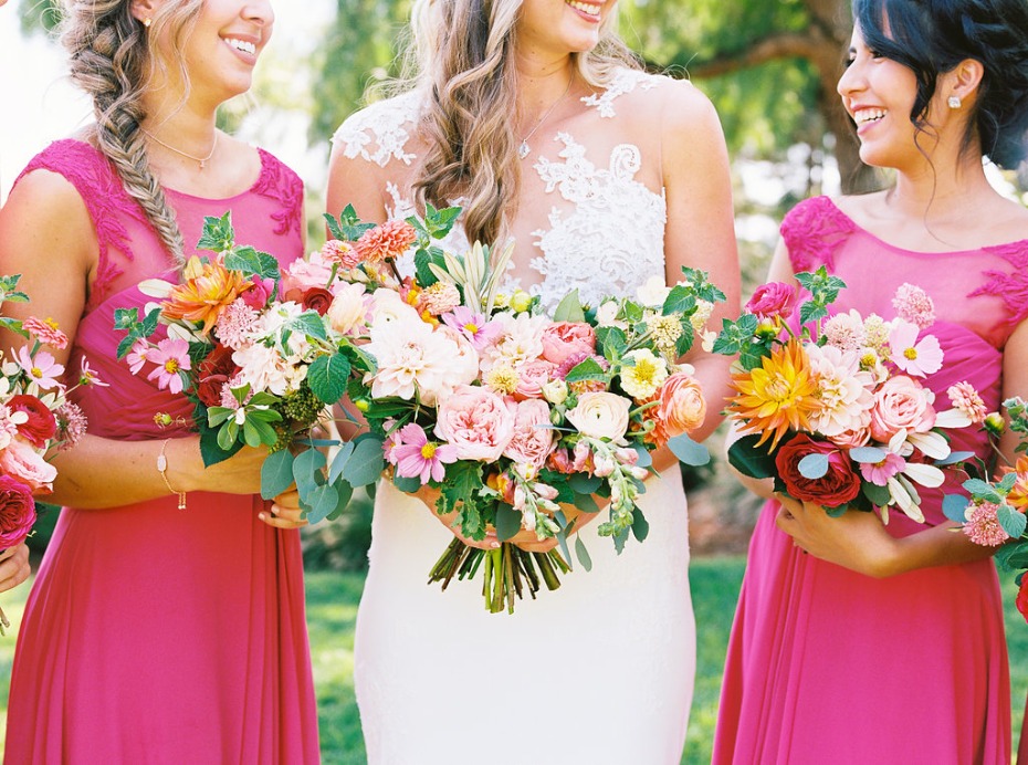 Bride and bridesmaids holding colorful wedding bouquets