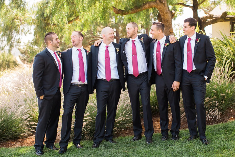Groomsmen in suits with pink ties at outdoor wedding