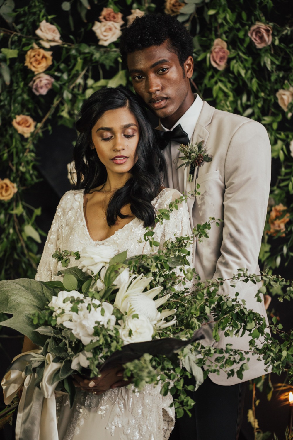 wedding couple with floral backdrop