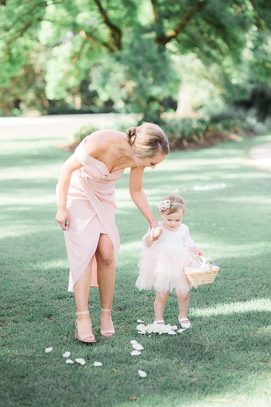 Bride and flower girl at a wedding, walking through a field