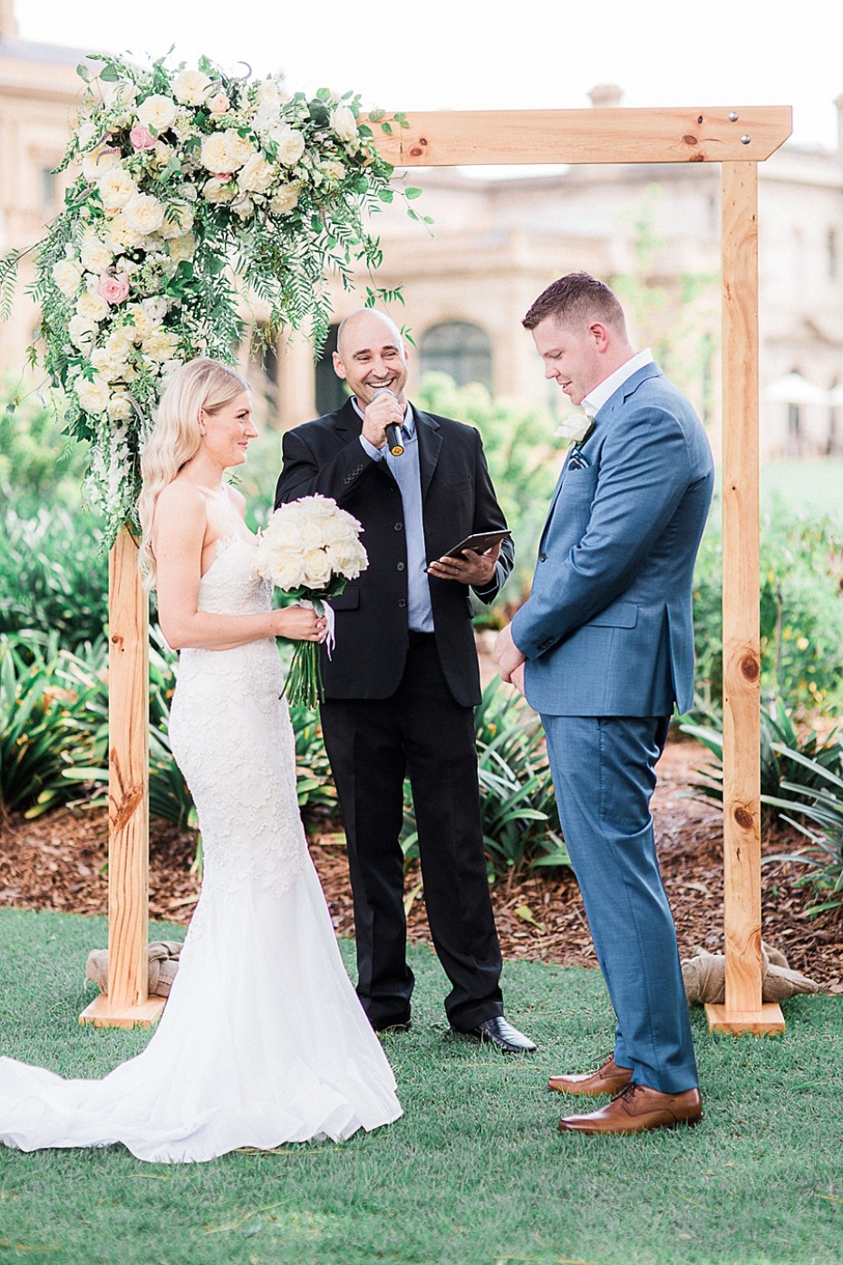 Bride and groom during wedding ceremony outdoors with arch