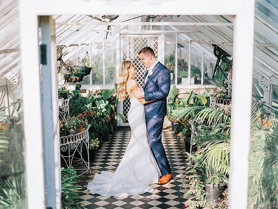 Romantic couple in greenhouse wedding, embracing and smiling