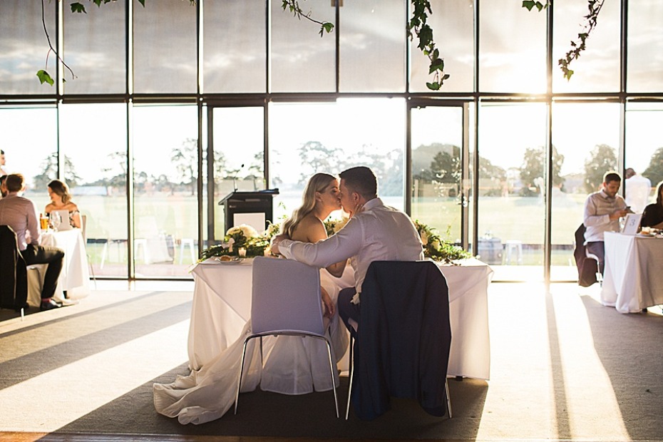 Newlyweds share a tender kiss at a wedding reception