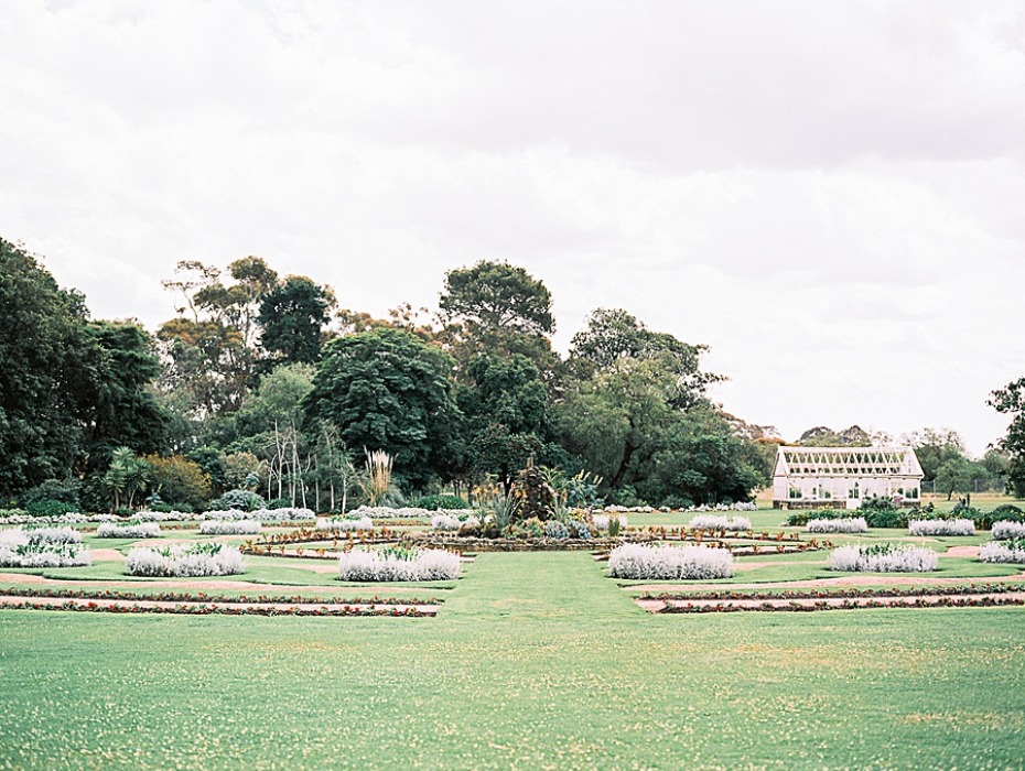 Formal garden landscape with white flowers and glass house