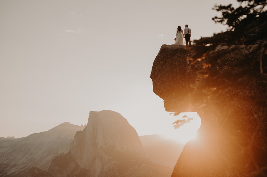 Bride and groom standing on cliff