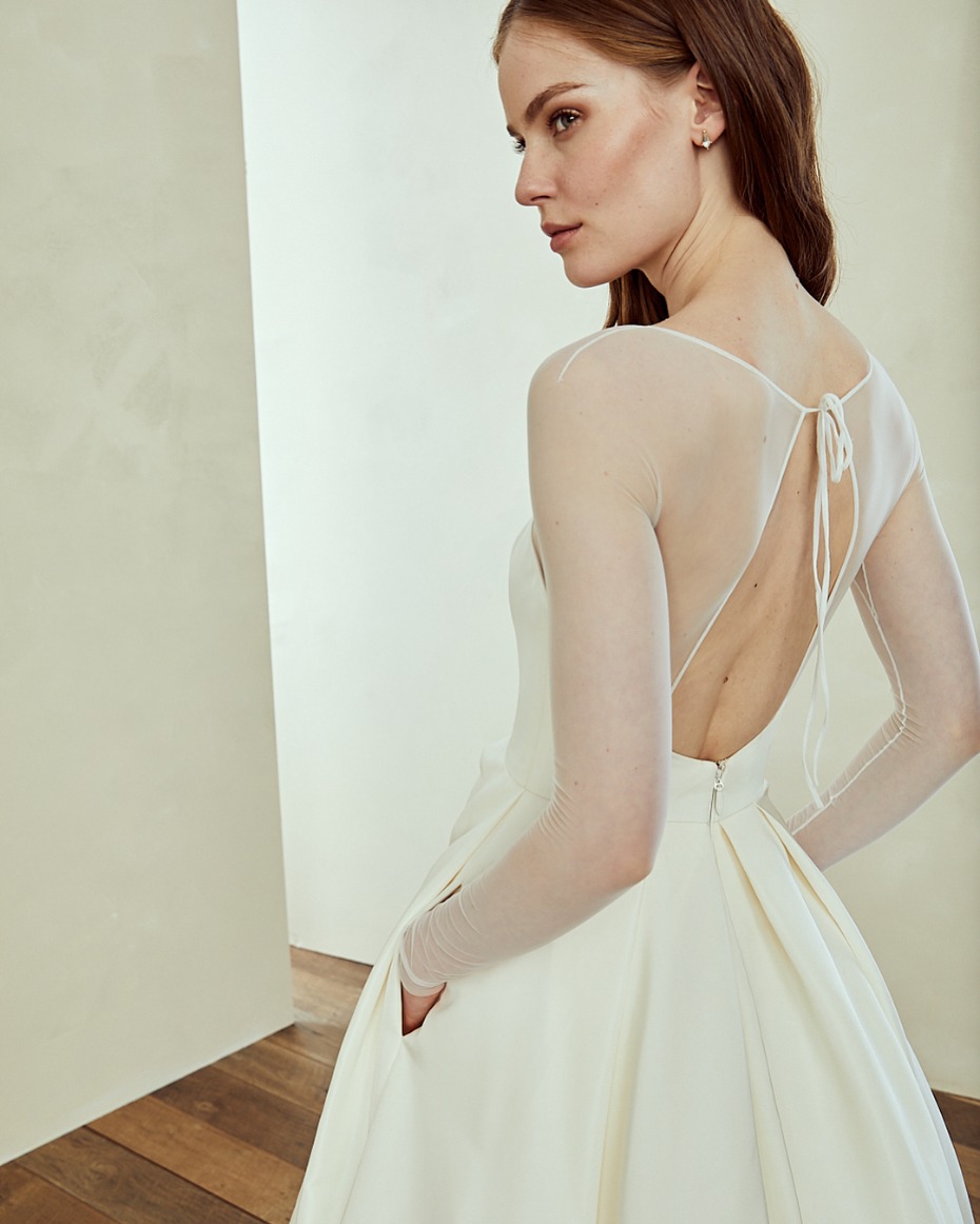 Elegant bride in flowing wedding gown with sheer sleeves