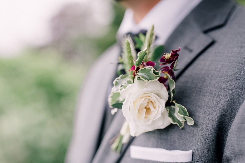 Groom's elegant grey suit with a white rose boutonniere