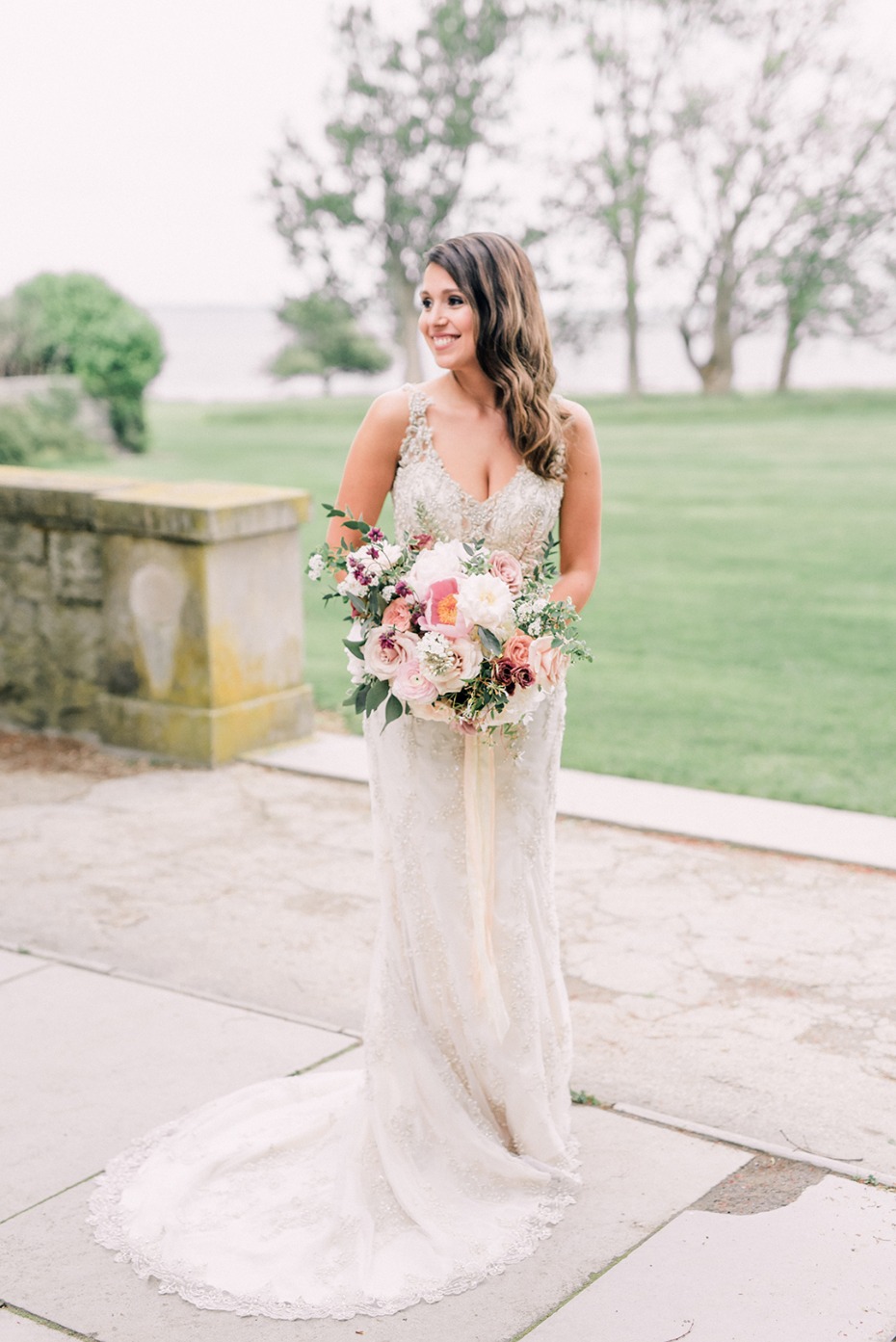 Beautiful bride in lace gown holding wedding bouquet