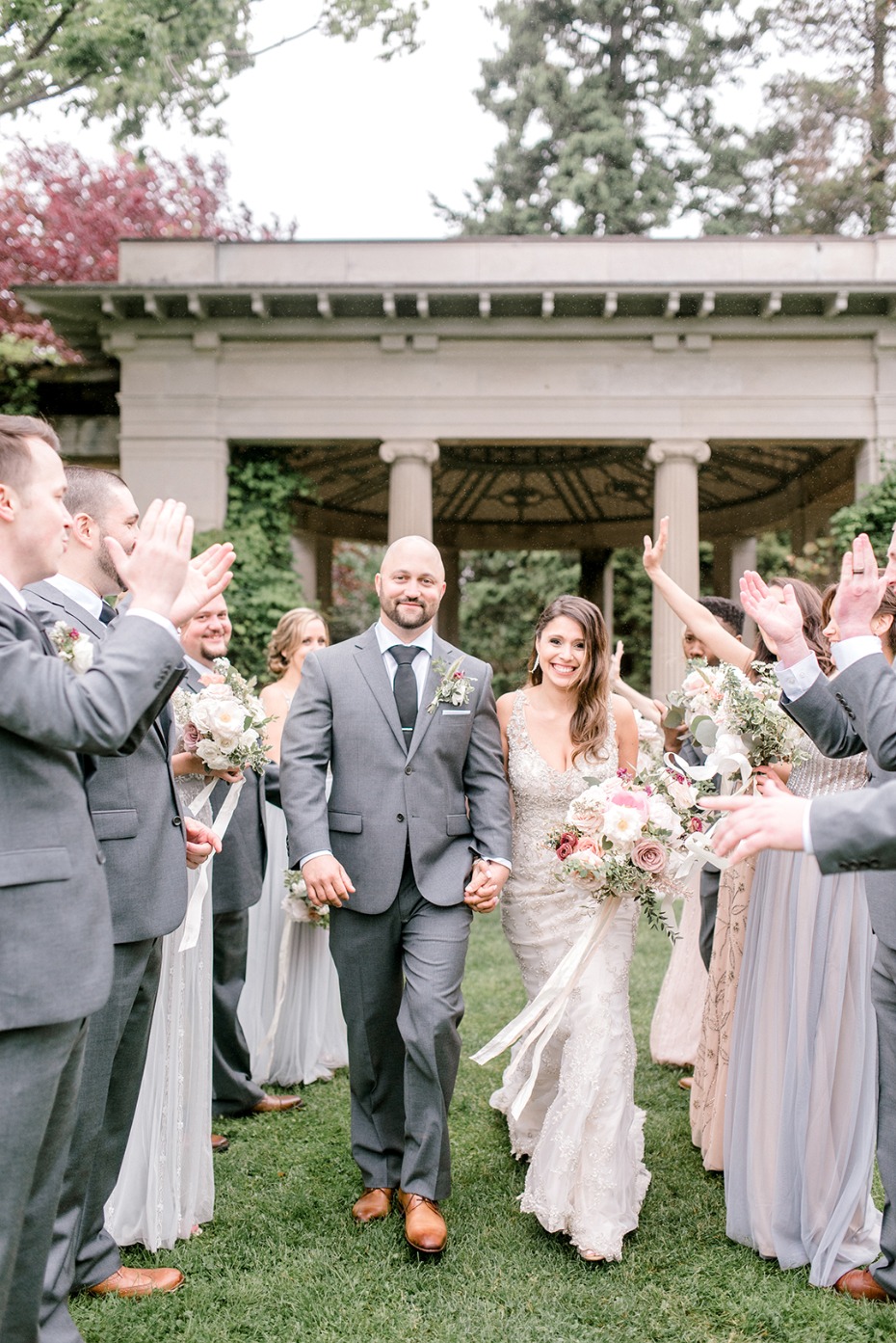 Newlyweds walk through a crowd of cheering wedding guests