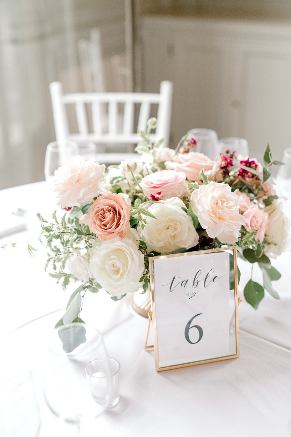 Elegant wedding table setting with floral centerpiece and table number 6
