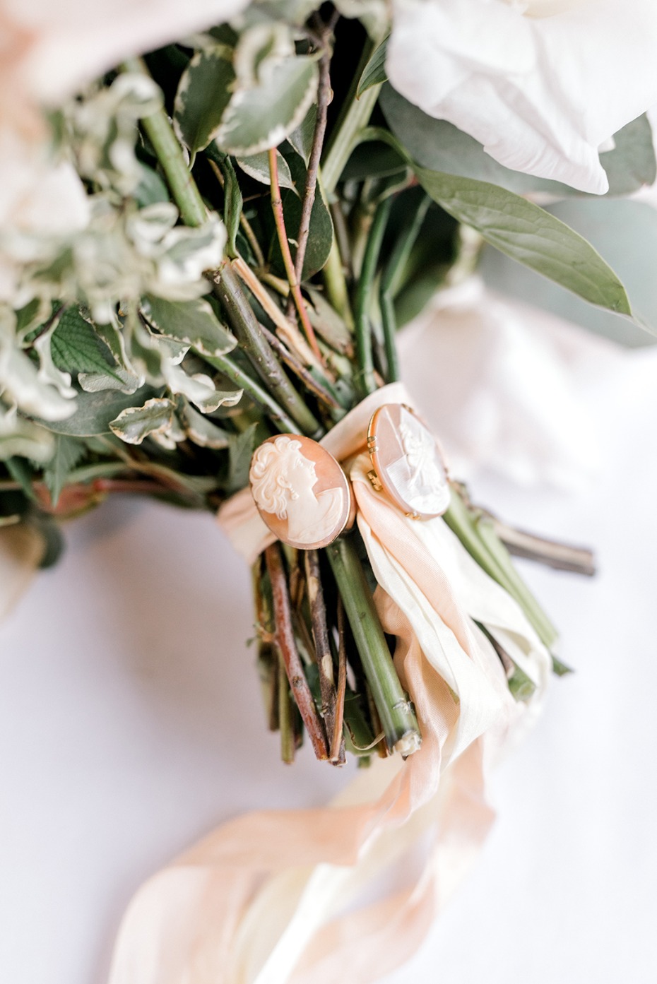 Elegant bouquet of white flowers with cameo earrings and ribbon