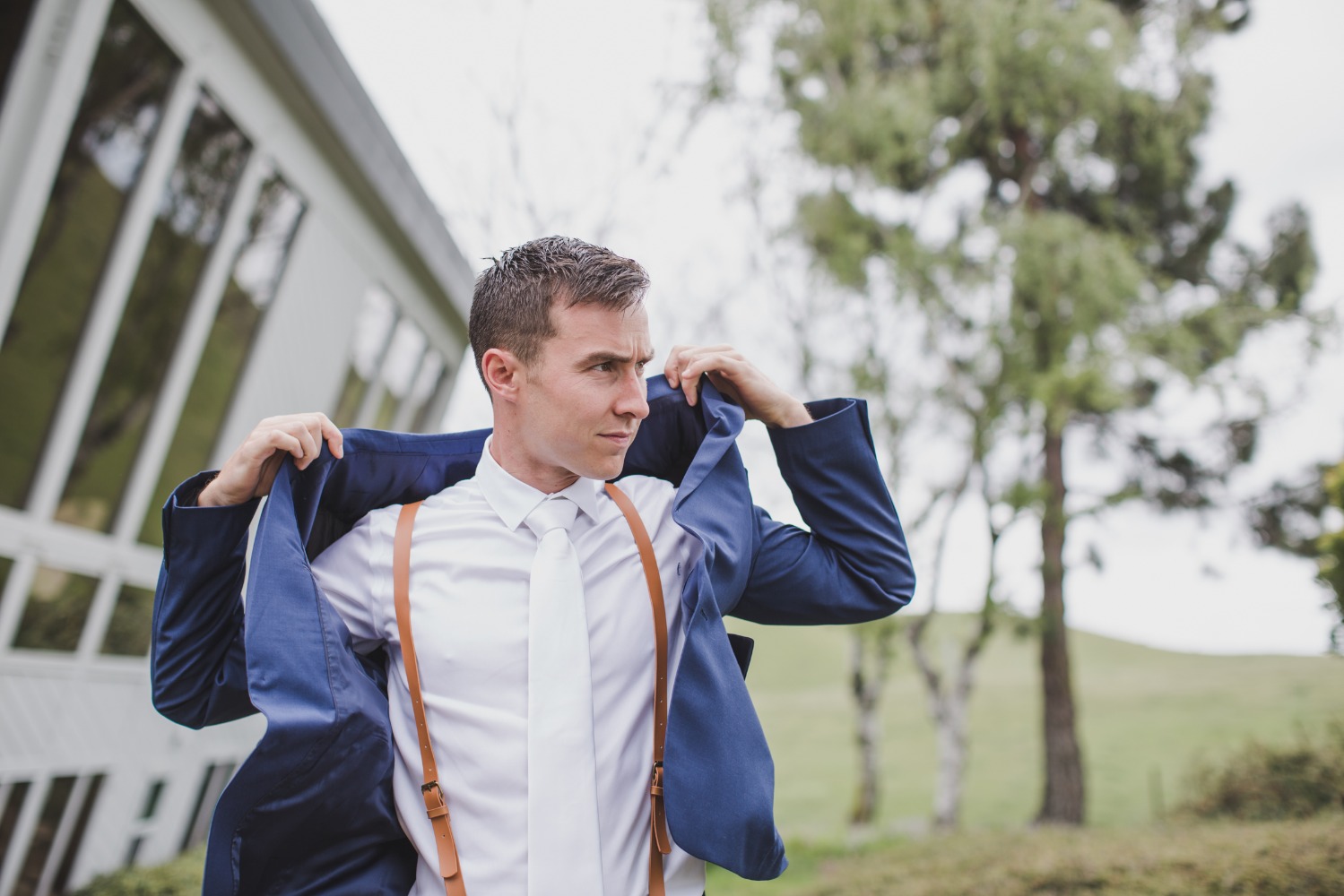 blue and white groom with leather suspenders