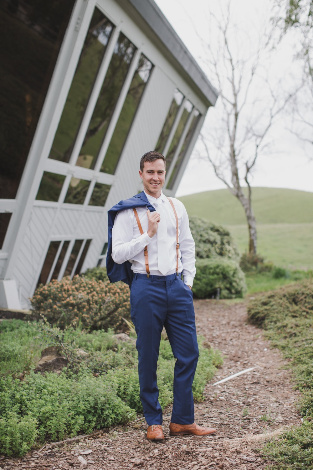 white and navy Groom outfit idea with leather suspenders